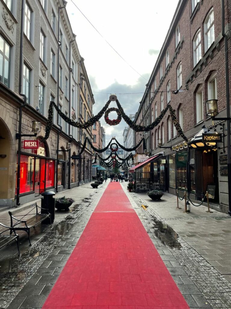 Sturegatan est une rue prestigieuse de Stockholm, célèbre pour ses boutiques haut de gamme, ses restaurants de qualité et son architecture historique. Cette photo capture l'essence de cette rue élégante, avec ses bâtiments en briques rouges, ses façades colorées et son ambiance sophistiquée. On peut voir des passants flâner le long des trottoirs pavés, des voitures rares circuler sur la chaussée et des arbres majestueux se balancer au-dessus de la rue. Sturegatan est également un lieu de rencontre pour les habitants et les visiteurs, où l'on peut voir des gens s'installer aux tables des cafés en terrasse pour discuter et prendre un verre. Que vous soyez un amateur de mode, de gastronomie ou simplement à la recherche d'une atmosphère sophistiquée, Sturegatan est une destination incontournable à Stockholm.